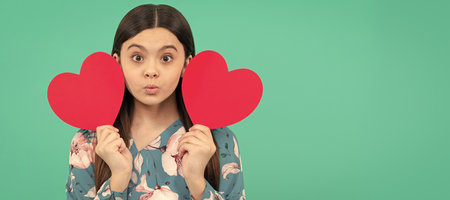 be my valentine. heart symbol of love. lovely beauty. pretty kid cupid. mothers or fathers day. Kid girl portrait with heart love symbol, horizontal poster. Banner header with copy space.の写真素材