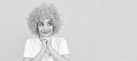 dreamy freaky woman in curly clown wig for party, dreaming. Woman isolated face portrait, banner with copy space.の写真素材