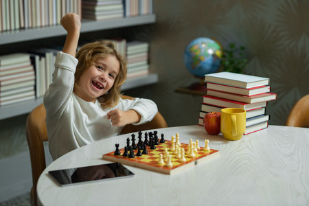 Excited child play chess. Kid playing board game. Thinking child brainstorming and idea in chess game. Chess school and education concept.の写真素材