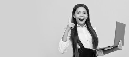 happy child in school uniform study on laptop inspired with idea, inspiration. School girl portrait with laptop, horizontal poster. Banner header with copy space.の写真素材