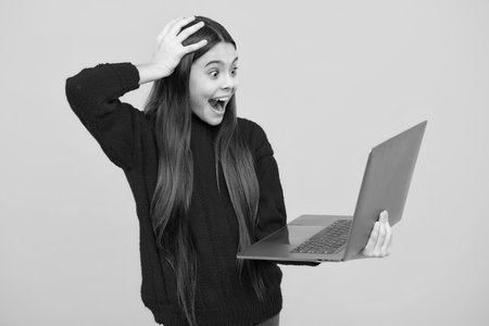 Excited face. Back to school, Teenager school girl with laptop computer. Amazed expression, cheerful and glad.の写真素材