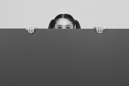 Teenage girl holds a blank for notification informing. Advertisement and sale. Markets and shops sales concept, blank board for copy space.の写真素材