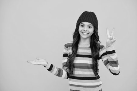 Fashion happy young woman in knitted hat and sweater having fun over colorful blue background. Happy teenager, positive and smiling emotions of teen girl.の写真素材