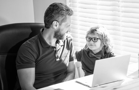 happy father helping his school son study with laptop at home, educationの写真素材