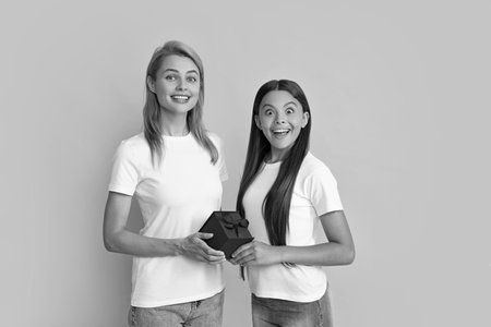 Family, child, holiday and party concept. Smiling mother and daughter with gift box. Cheerful mom and her cute daughter girl with gifts. Parent and child having fun.の写真素材