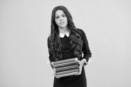 Schoolgirl with copy book posing on isolated background. Literature lesson, grammar school. Intellectual child reader. Angry teenager girl, upset and unhappy negative emotion.の写真素材