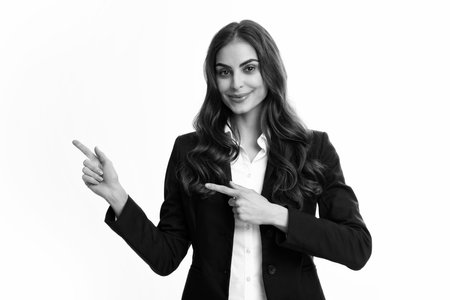 Female student, young teacher. Woman point at copy space, showing copyspace pointing. Promo, girl showing advertisement content gesture, pointing with hand recommend product. Isolated background.の写真素材