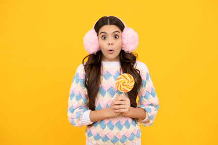 Teenager girl with caramel candies on sticks, sweet sugar addiction. Child with lollipops. Surprised emotions of young teenager girl.の写真素材