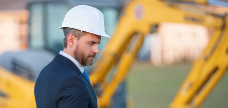 Worker in suit and helmet. Investor civil engineer, construction manager. Construction building developer at a construction site. Successful architect. Handsome hispanic builder man in suit.の写真素材