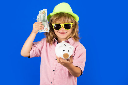 Dollars money banknotes and piggy bank concept. Kid putting coin into piggy bank for saving with pile of coins. Piggybank with coins and child concept.の写真素材