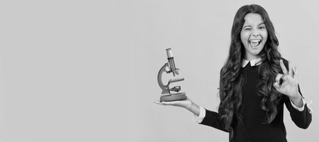 chemistry laboratory. research education. ok. happy scientist kid with microscope. Portrait of school girl student, studio banner header. School child pupil face, copy space.の写真素材