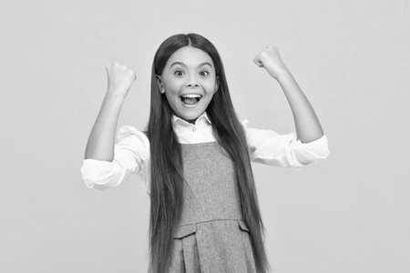 Amazed teen girl. Excited expression, cheerful and glad. Joy, victory, celebration and excitement concept. Euphoric child celebrating success and achievement, feeling excited saying Yes. Excited face.の写真素材