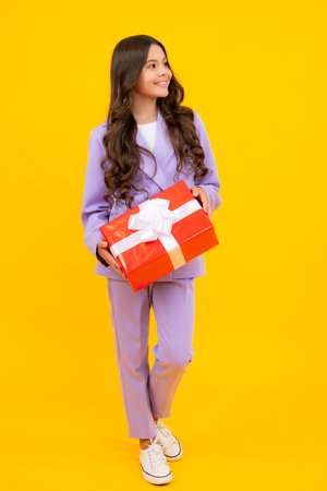 Emotional teenager child hold gift on birthday. Funny kid girl holding gift boxes celebrating happy New Year or Christmas.の写真素材
