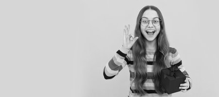 Child girl gift. seasonal sales. amazed teen girl in eyeglasses with box. boxing day. present and gifts buy. Kid girl with gift, horizontal poster. Banner header with copy space.の写真素材