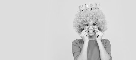 pure happiness. fancy party look. egocentric kid in clown wig and crown. Funny teenager child in wig, party poster. Banner header, copy space.の写真素材