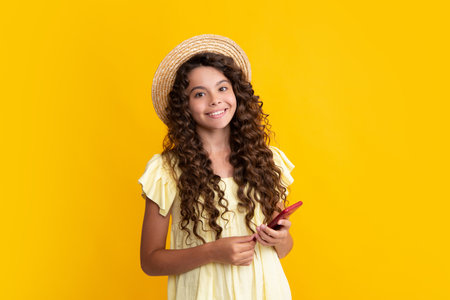 Mobile online shopping. Cute teen child girl paying with phone, texting and chatting on smartphone. Happy teenager, positive and smiling emotions of teen girl.の写真素材
