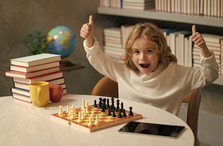 Clever excited amazed child boy playing chess.の写真素材
