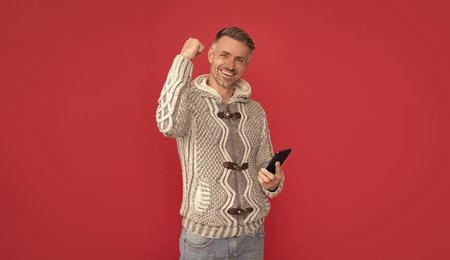 glad male fashion model hold smartphone. concept of modern communication