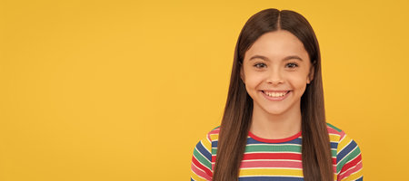 Happy girl child smile yellow background. Child face, horizontal poster, teenager girl isolated portrait, banner with copy space.の写真素材