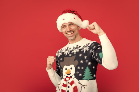 Portrait of man scream wow omg point thumb at copy space hear incredible news of christmas time theme party wear pullover isolated on red studio background.の写真素材