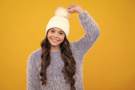 School girl in winter clothes and warm hat. Winter holiday vacation. Child fashion model. Happy girl face, positive and smiling emotions.の写真素材