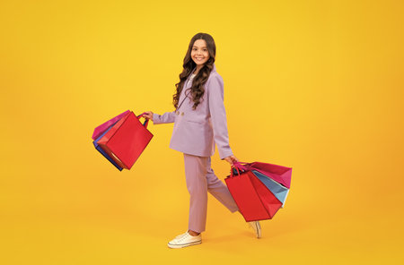 Stylish teen girl with shopping sale bags. Kid holding purchases.の写真素材