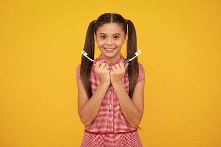 Dental care, hygiene and child. Teenage girl with toothbrush brushing teeth. Happy teenager, positive and smiling emotions of teen girl.の写真素材