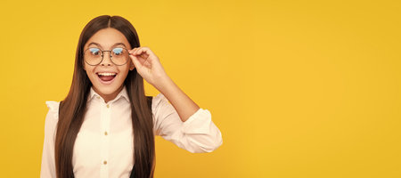 amazed teen girl in school uniform and glasses for vision protection, eyewear. Child face, horizontal poster, teenager girl isolated portrait, banner with copy space.の写真素材