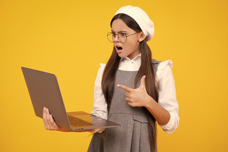 Back to school, Teenager school girl with laptop computer. Angry face, upset emotions of teenager girl.の写真素材