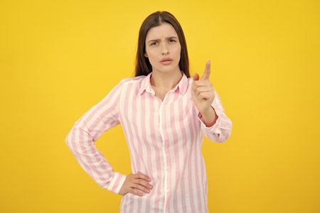 Negative woman show no decline forbidden rule isolated over yellow background. Displeased angry woman blocking offer, showing cross stop gesture, negative reply.の写真素材