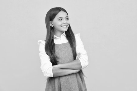 Close up portrait of caucasian teen girl. Head shot of cute teenager child on yellow isolated studio background. Happy girl face, positive and smiling emotions.の写真素材