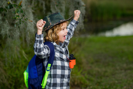 Travel and adventure concept. Little child boy tourist explorer with binoculars on nature. Discovery, exploring and education.の写真素材