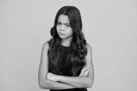 Angry teenager girl, upset and unhappy negative emotion. Headshot portrait of teenager child girl isolated on studio background. Childhood lifestyle concept. Mock up copy space.の写真素材