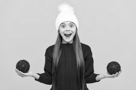 amazed child in winter hat with decoration ball, xmasの写真素材