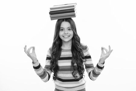 Schoolgirl with copy book posing on isolated background. Literature lesson, grammar school. Intellectual child reader. Happy girl face, positive and smiling emotions.の写真素材