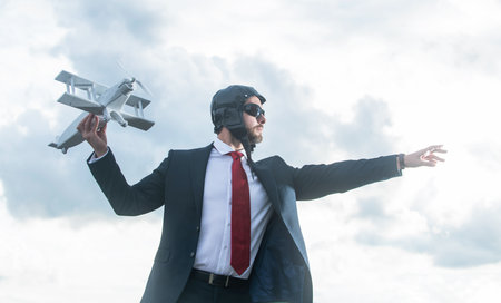 businessman in suit and pilot hat launch plane toy. innovate ideaの写真素材