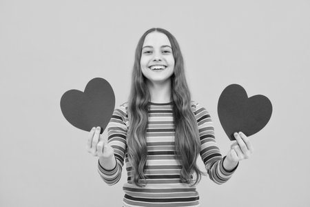 Happiness kids and love concept. Romantic lovely teen girl with red heart, world heart day, happy valentines day.の写真素材