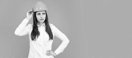 Woman isolated face portrait, banner with mock up copy space. Architect businesswoman in helmet thinking, young caucasian female in work as constructor engineer.の写真素材