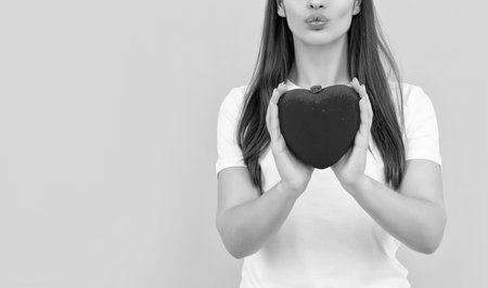 lady in white shirt with heart blow kiss on yellow background, 14 februaryの写真素材