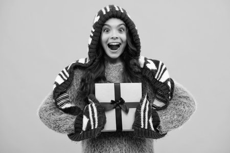 Teenager child with gift box. Present for holidays. Happy birthday, Valentines day, New Year or Christmas. Kid hold present box. Happy teenage girl, positive and smiling emotions.の写真素材