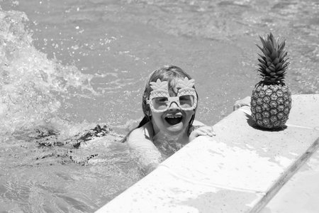 Happy child playing in swimming pool. Summer kids vacation. Little kid boy relaxing in a pool having fun during summer vacation.の写真素材