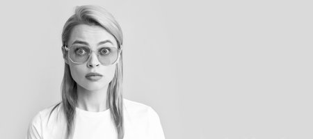 portrait of amazed young woman in glasses, fashion. Woman isolated face portrait, banner with copy space background.の写真素材