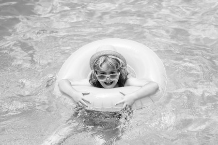 Kids swimming and playing in a pool. Child playing in swim pool. Summer fashion kids portrait....