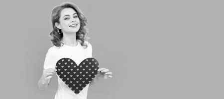 happy young woman with red heart on blue background. Woman isolated face portrait, banner with mock up copyspace.の写真素材