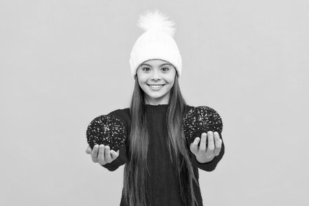 happy kid in hat with snowballs on yellow background, christmasの写真素材