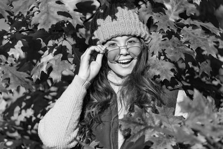 happy teen girl in sunglasses at autumn leaves on natural backgroundの写真素材