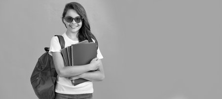 back to school. knowledge day. education. kid in glasses hold copybook. Horizontal isolated poster of school girl student. Banner header portrait of schoolgirl copy space.の写真素材