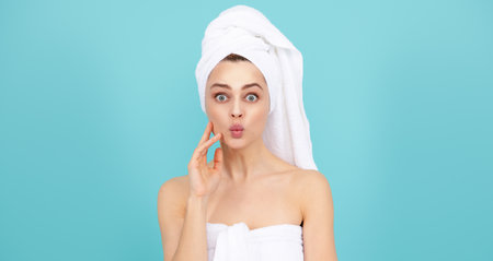 Surprised woman with towel on head. Clean skin face, facial care. Fresh and clear skin, face care routine. Woman skincare. Beauty face cosmetology. Perfect skin of beauty girl. Beauty and spa.の写真素材