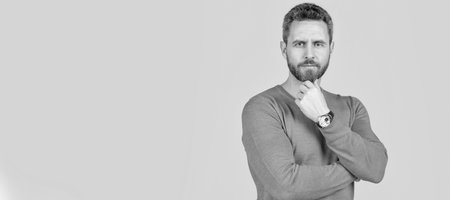 handsome mature man with beard on grey background with wristwatch, accessory. Man face portrait, banner with copy space.の写真素材