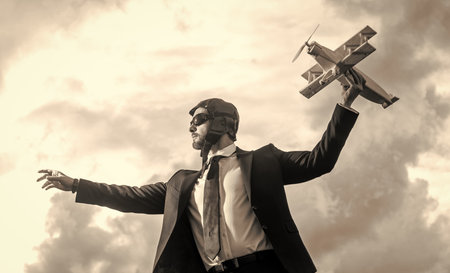 businessman in suit and pilot hat launch plane toy. ideasの写真素材